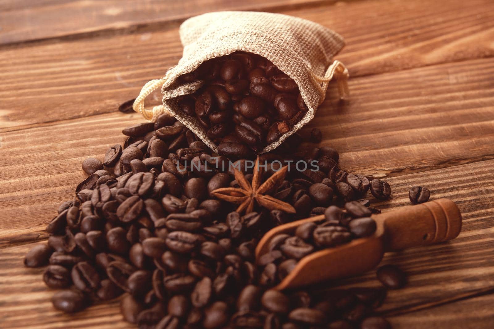 Close up of roasted coffee beans with anise in sackcloth bag on a wooden background Coffee is always a good idea by Iryna_Melnyk