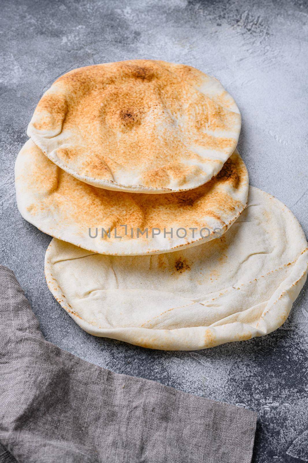 Freshly baked pita bread set, on gray stone table background by Ilianesolenyi