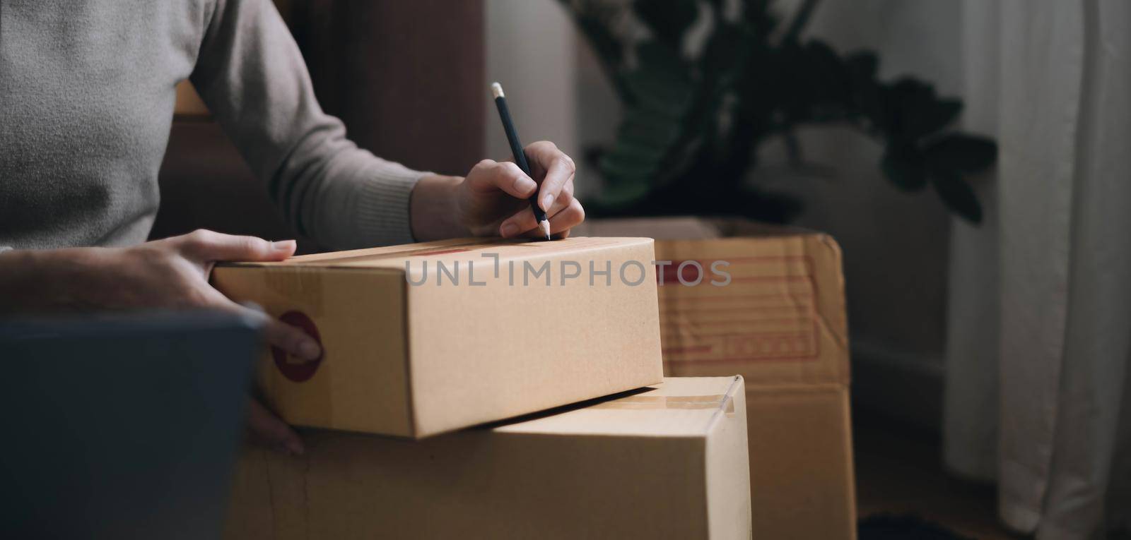 Starting small businesses SME owners female entrepreneurs Write the address on receipt box and check online orders to prepare to pack the boxes, sell to customers, sme business ideas online. by wichayada