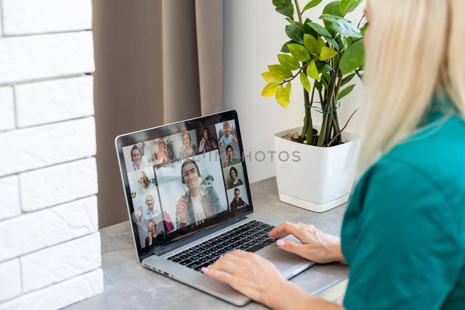 Cropped image of young woman using laptop for video conference at home by Andelov13