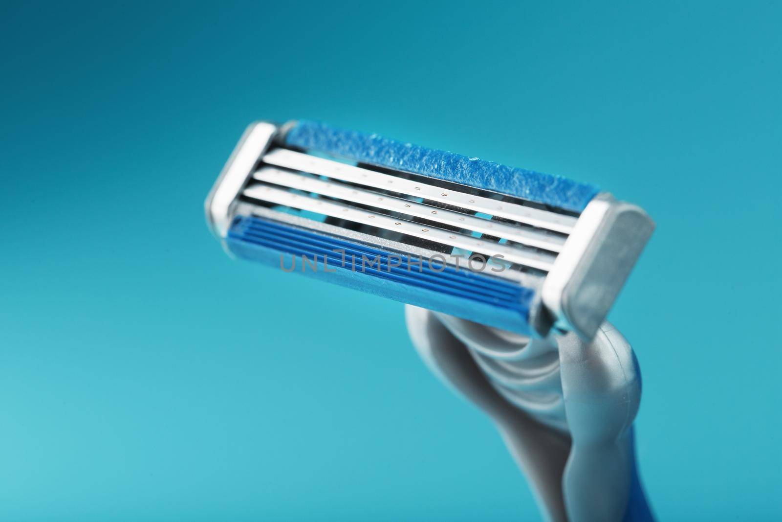Shaving machine with three blades on a blue background close-up free space by AlexGrec