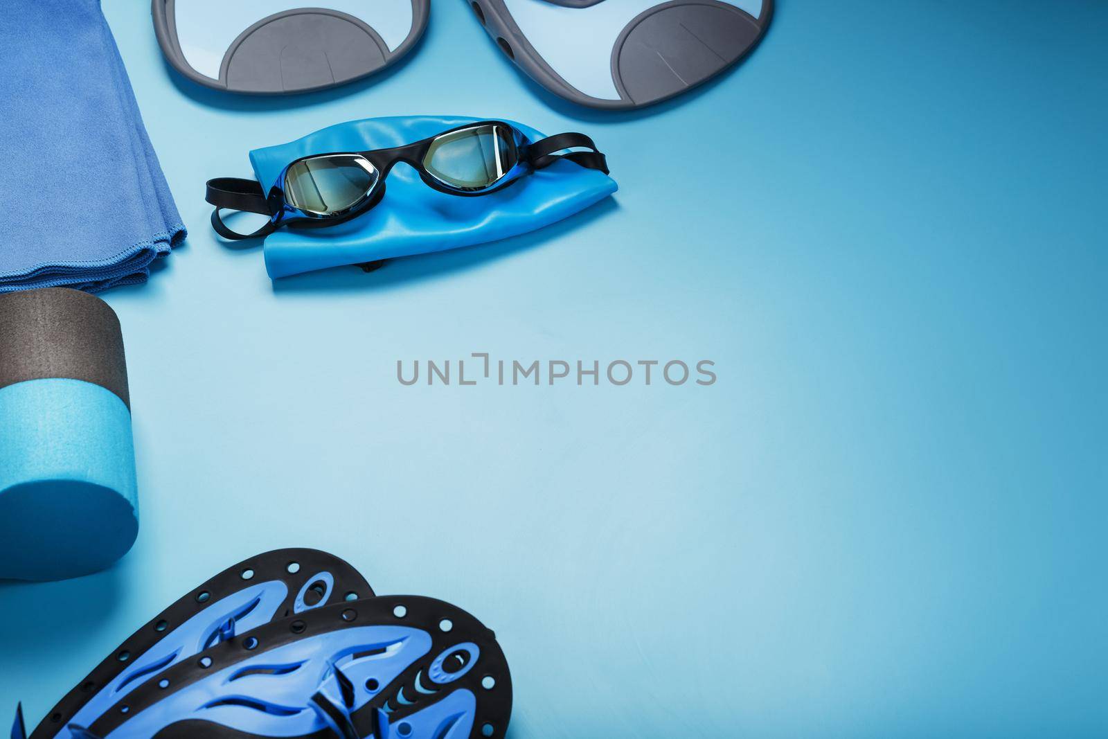 Sports equipment for swimming in the pool and open water on a blue background, close-up