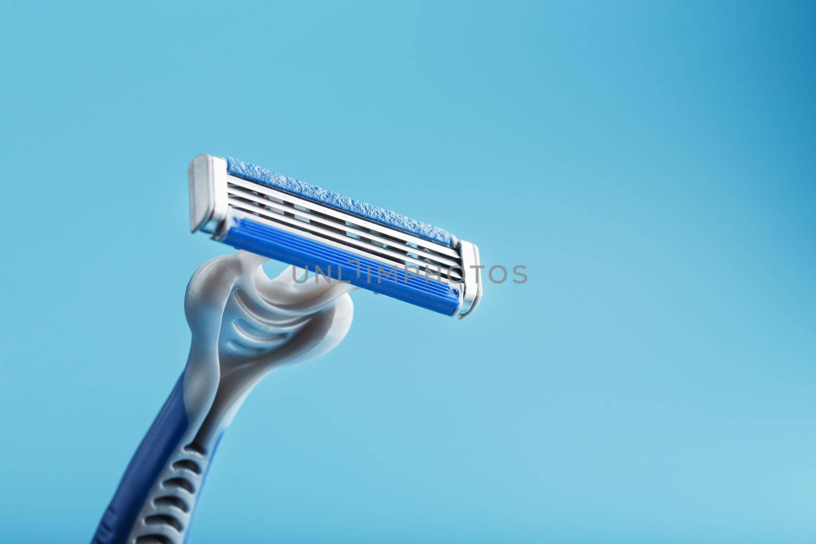Shaving machine with three blades on a blue background close-up free space