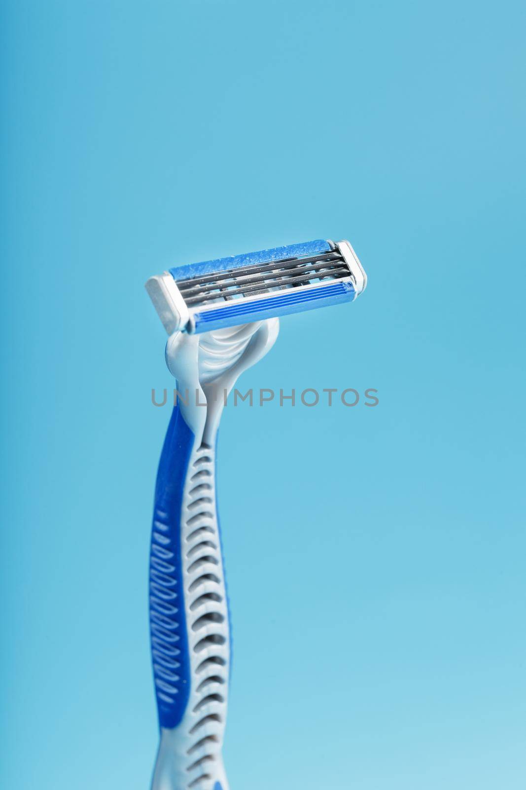 Blades of a new shaving machine on a blue background close-up free space