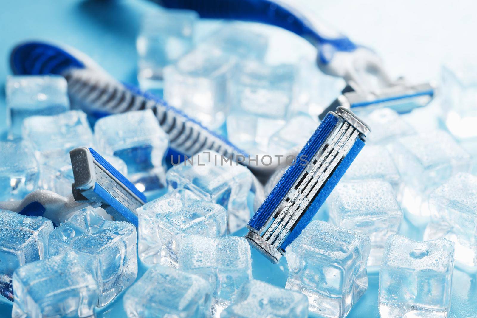 Three shaving machines on a frosty blue background with ice. The concept of cleanliness and frosty freshness by AlexGrec
