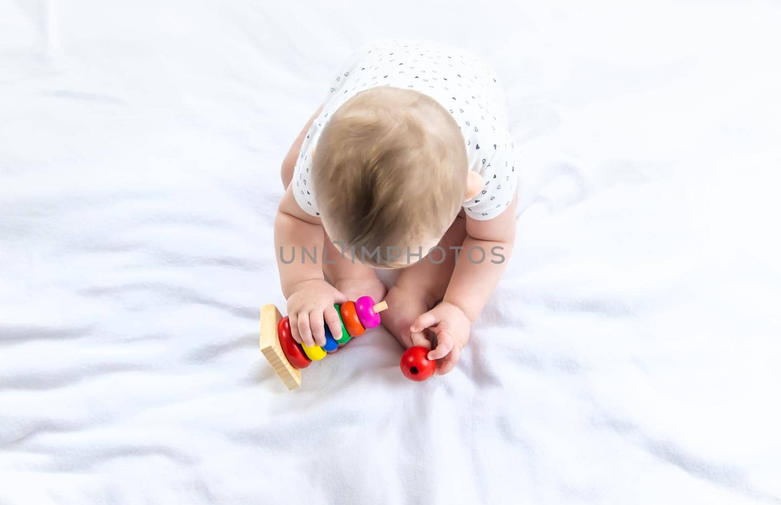 Baby plays with a pyramid at home. Selective focus. by yanadjana