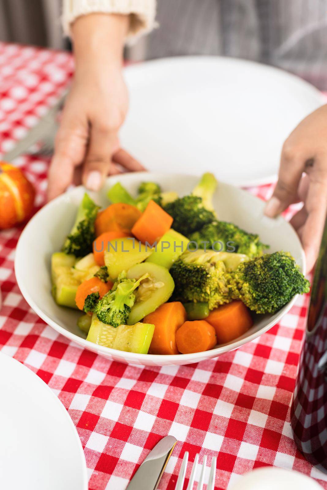 woman preparing vegetables for thanksgiving dinner at home kitchen by Desperada