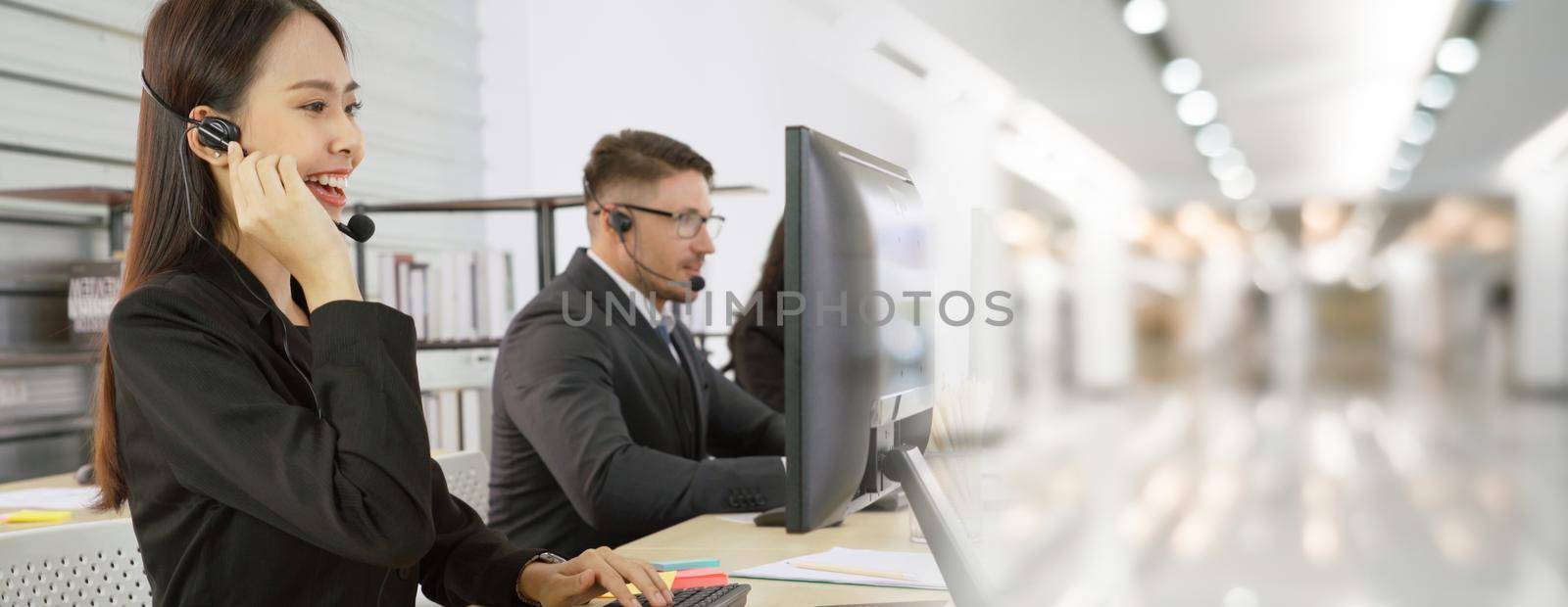 Business people wearing headset working in office to support remote customer or colleague. Call center, telemarketing, customer support agent provide service in broaden view .