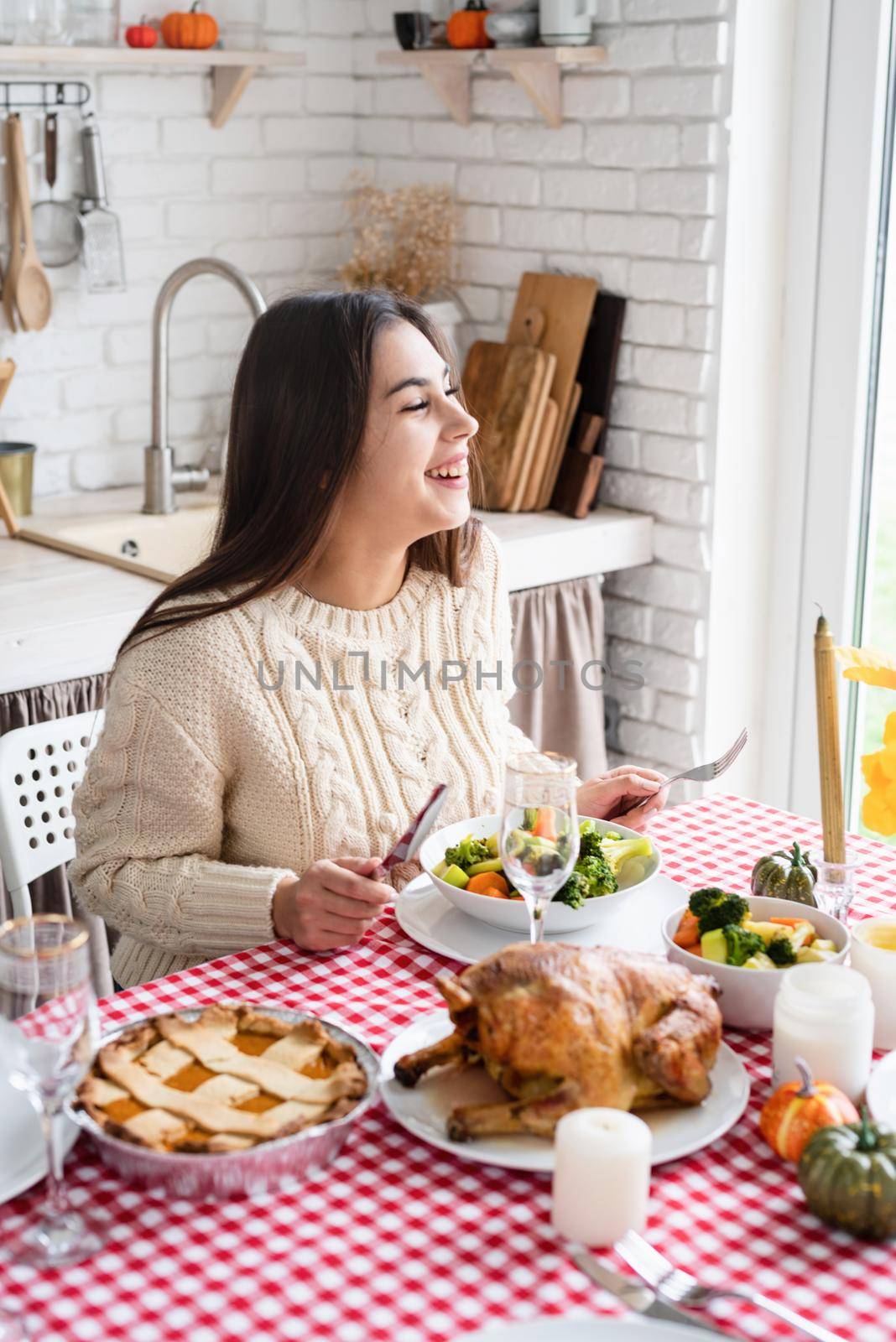 woman having thanksgiving dinner at home kitchen celebrating holiday by Desperada