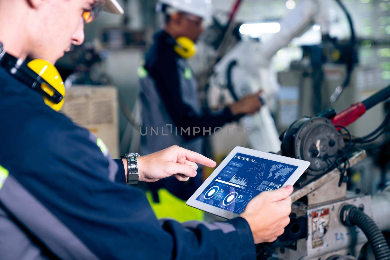 Factory workers working with adept robotic arm in a workshop . Industry robot programming software for automated manufacturing technology .