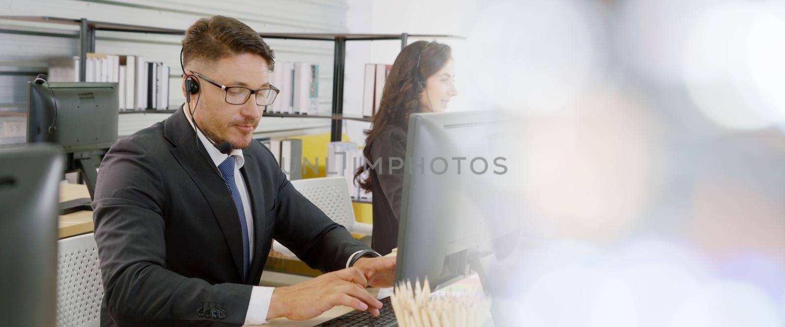 Business people wearing headset working in office broaden view by biancoblue