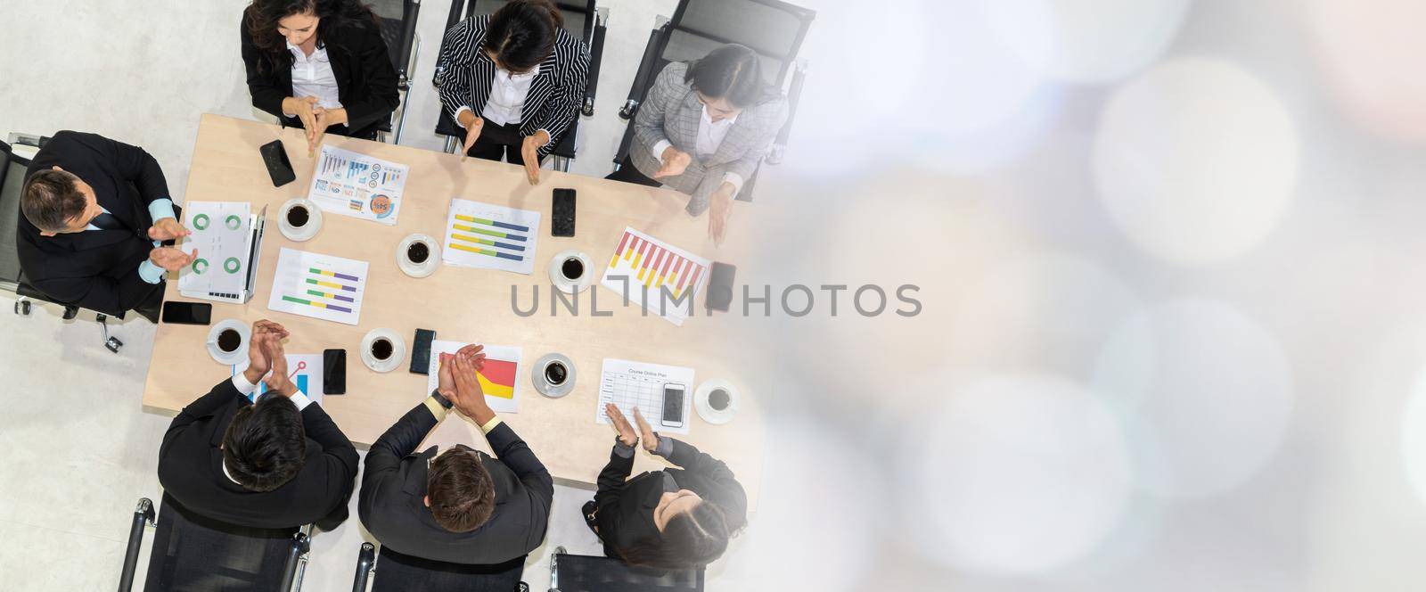 Successful business people celebrate together with joy at office table shot from top view . Young businessman and businesswoman workers express cheerful victory showing teamwork in broaden view .