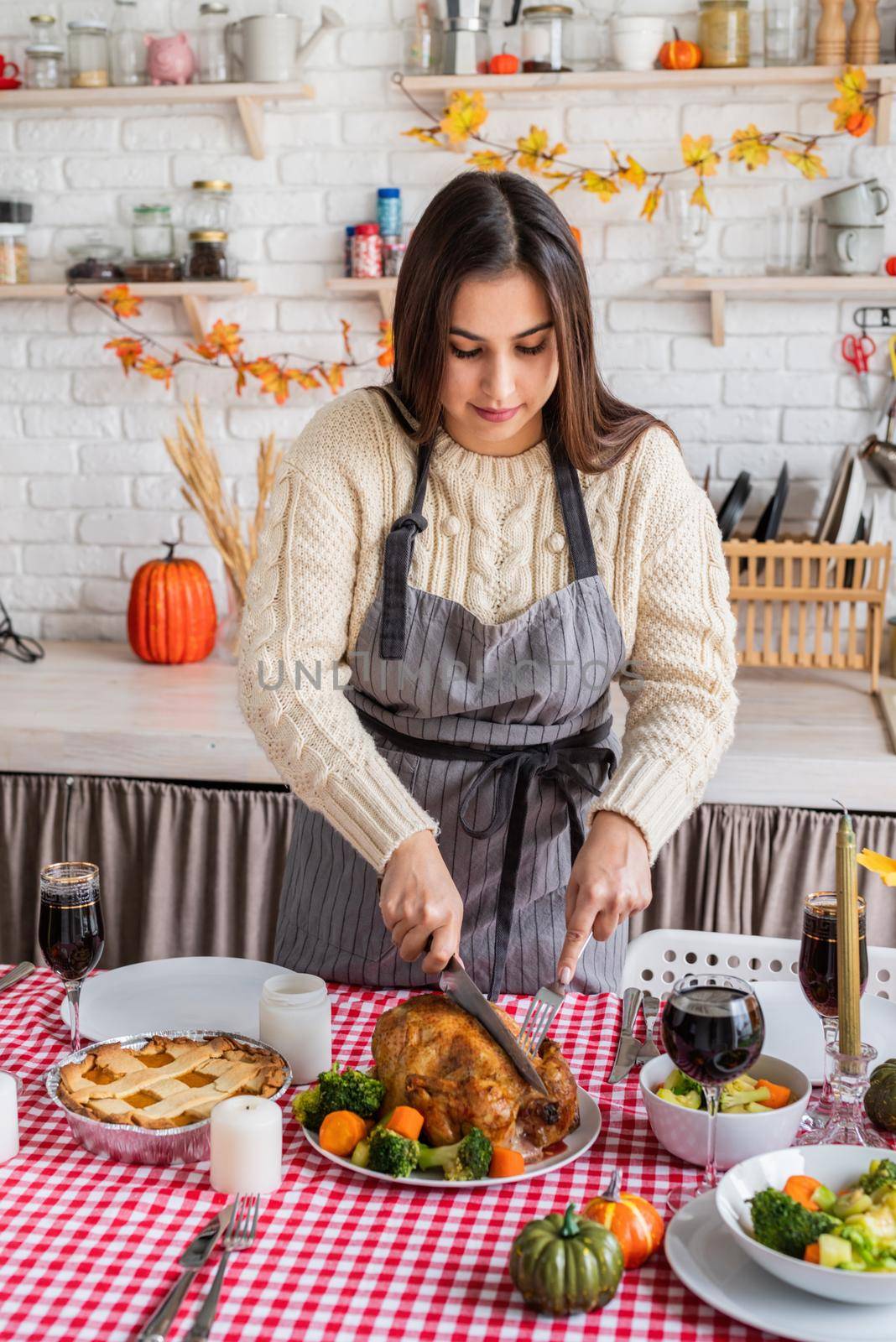 Happy Thanksgiving Day. Autumn feast. Woman celebrating holiday cooking traditional dinner at kitchen with turkey, vegetables and pumpkin pie