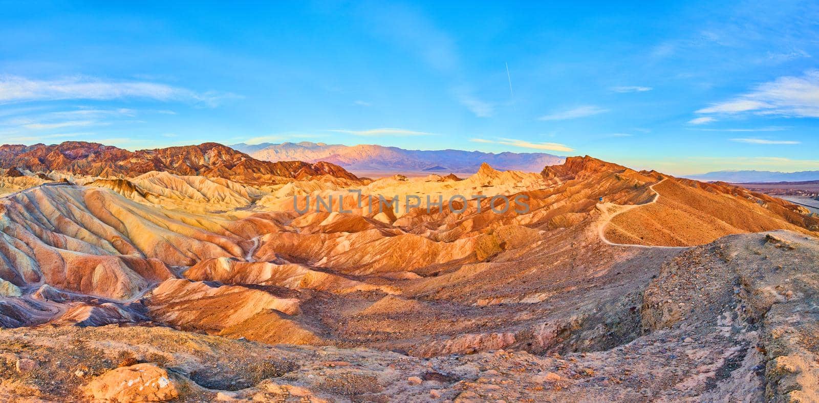 Image of Mountains featuring waves of sediment colors and hiking path through the peaks in Death Valley
