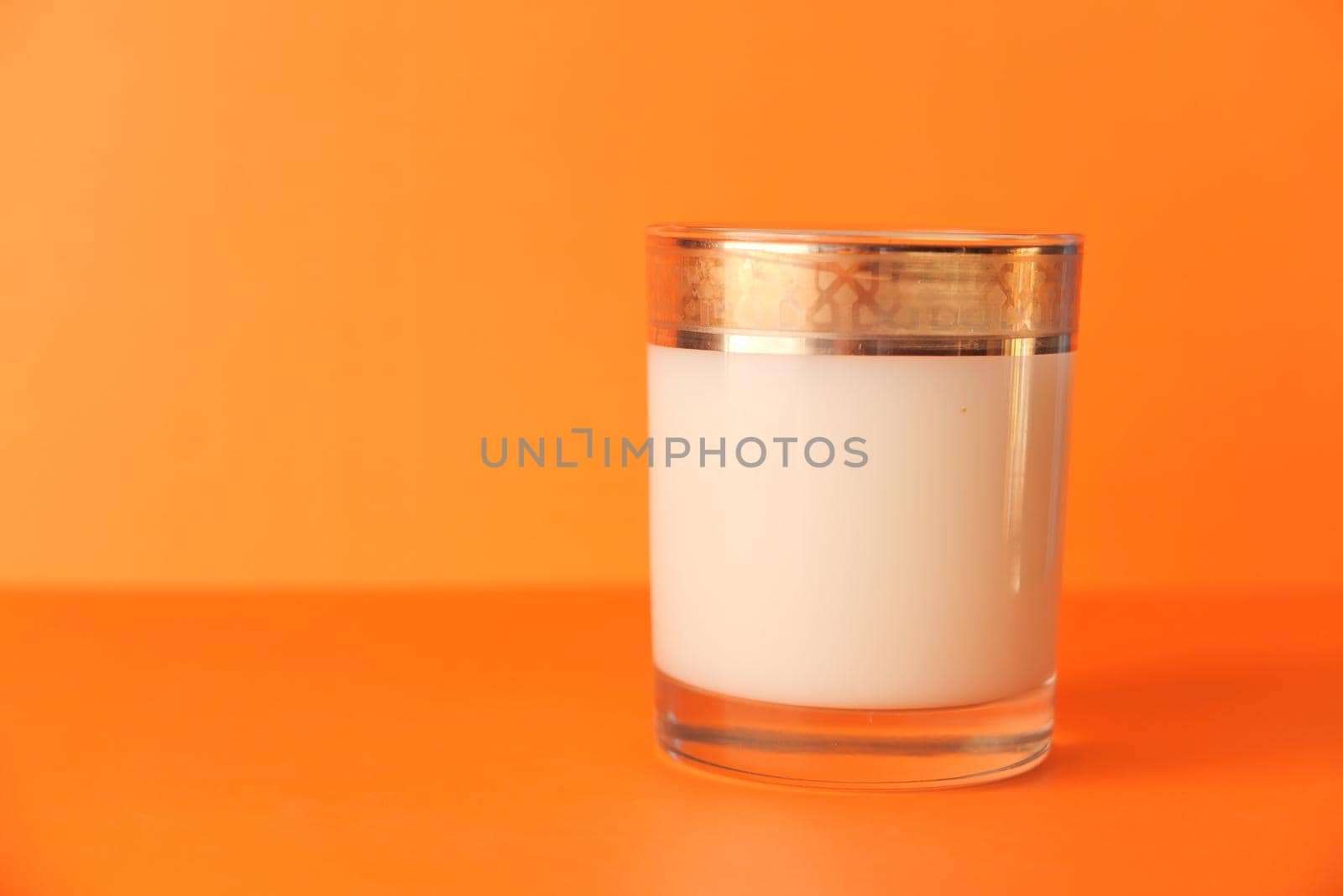 close up of bottle of milk on orange background .
