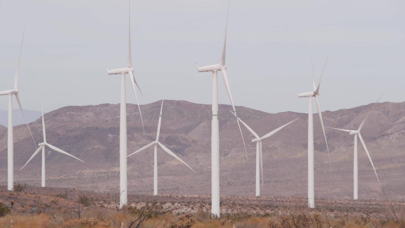 Windmills turbine rotating, wind farm or power plant, alternative green renewable energy generators, industrial field in California desert USA. Electricity generation on windfarm. El Centro, Kumeyaay.