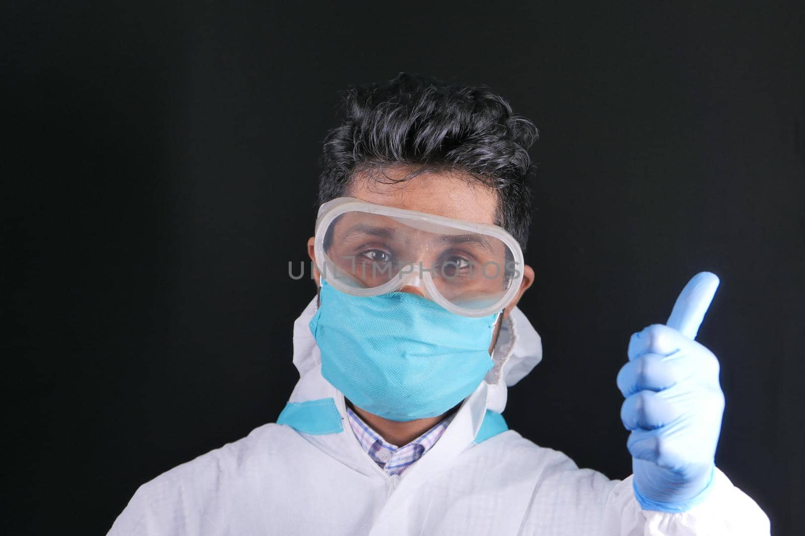 young doctor's hand in medical gloves showing a thumb-up..