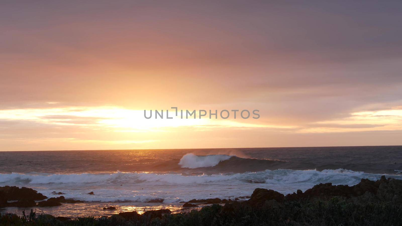Rocky ocean coast sea waves, Monterey beach California, birds flying, sunset sky by DogoraSun