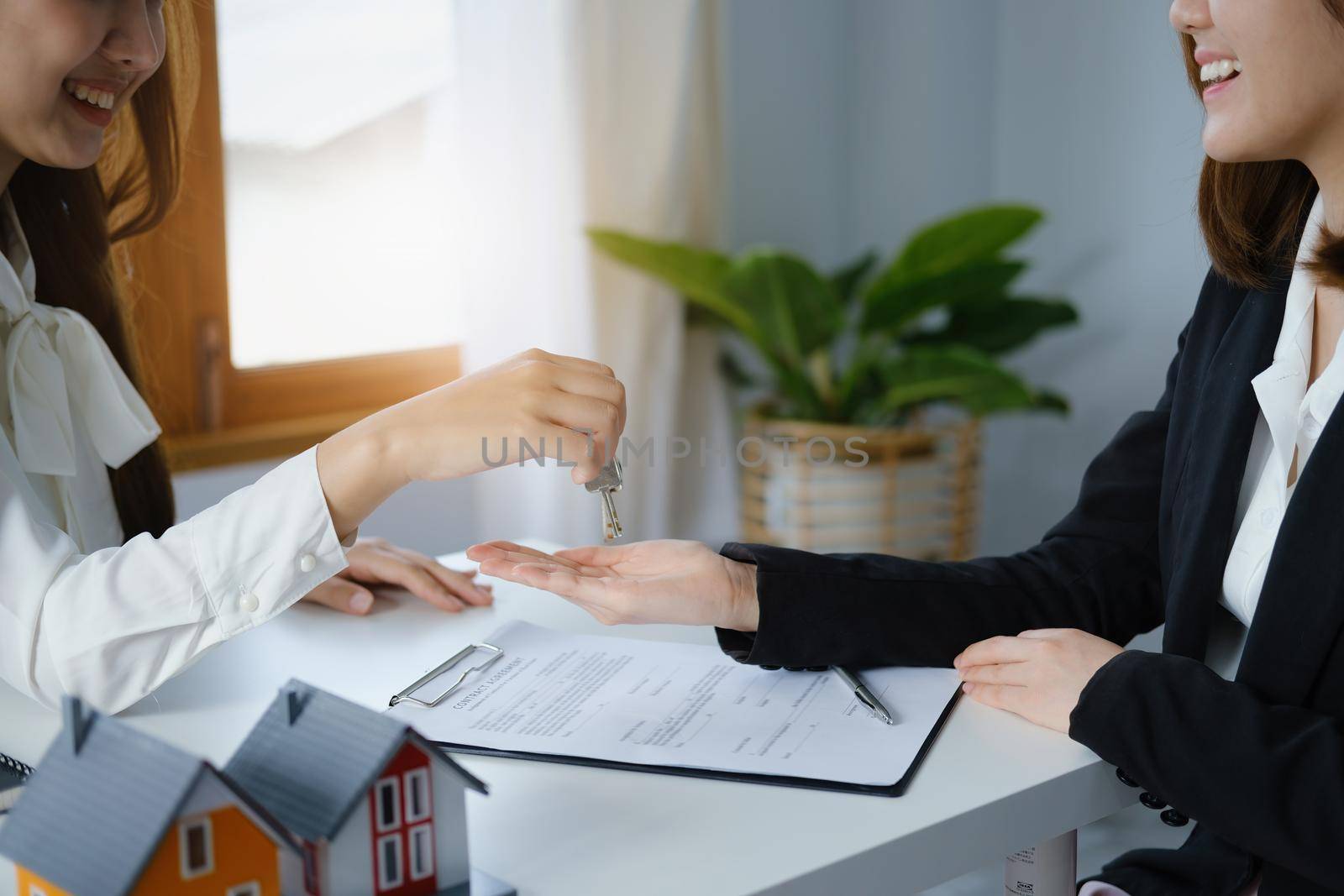 Guarantee, mortgage, agreement, contract, sign, real estate agent delivers the key to the customer after signing important contract documents by Manastrong