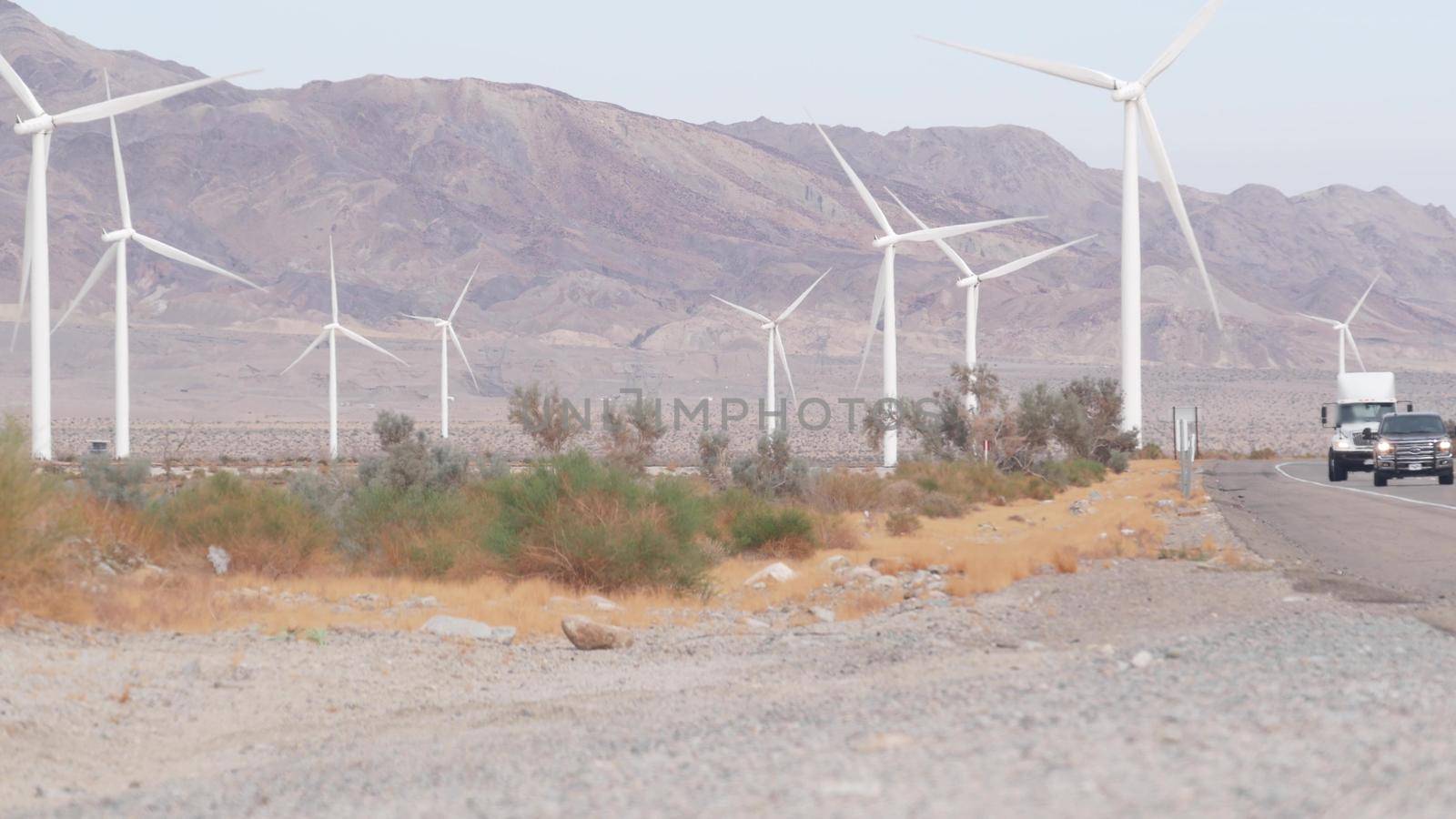 Windmills turbine rotating, wind farm or power plant, alternative green renewable energy generators, industrial field in California desert USA. Electricity generation on windfarm. El Centro, Kumeyaay.