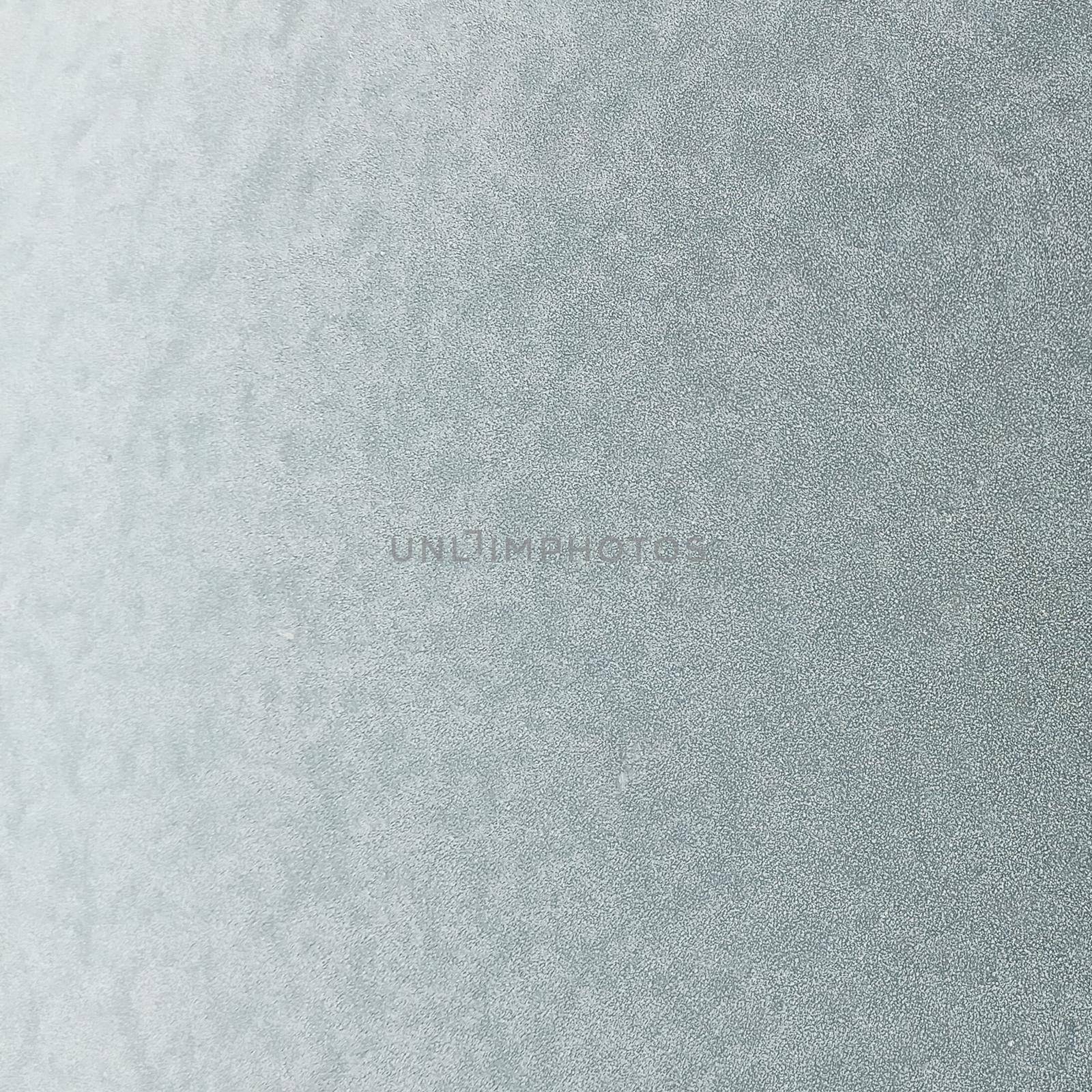The frozen hood of the car. Frost on the metal surface of the car with a gray blur effect. Abstract background and texture for design.