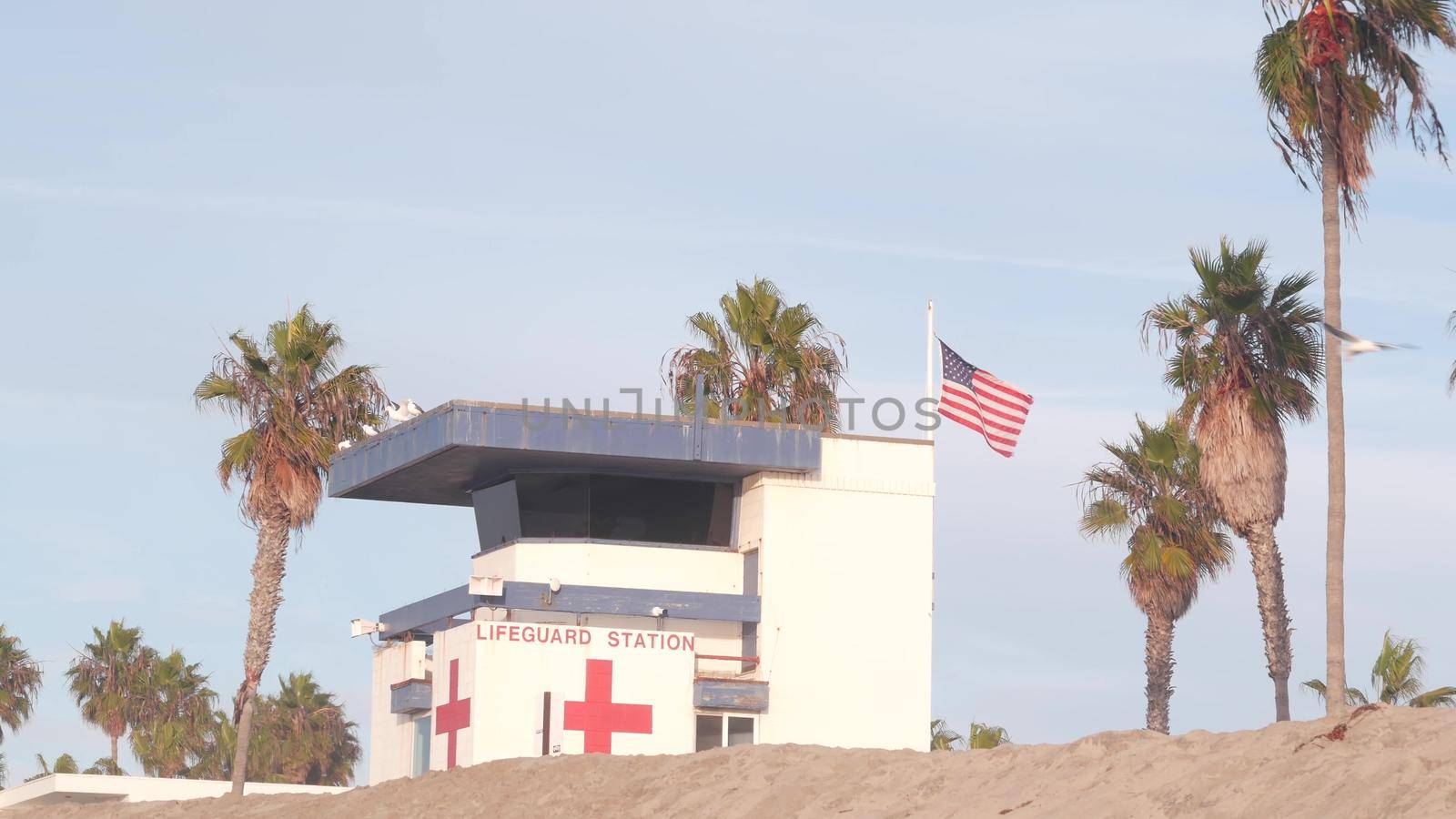Lifeguard stand, life guard tower hut, surfing safety on California beach, USA. Summer pacific ocean aesthetic. Rescue station, coast lifesavers wachtower or house, palm trees, Ocean Beach, San Diego.