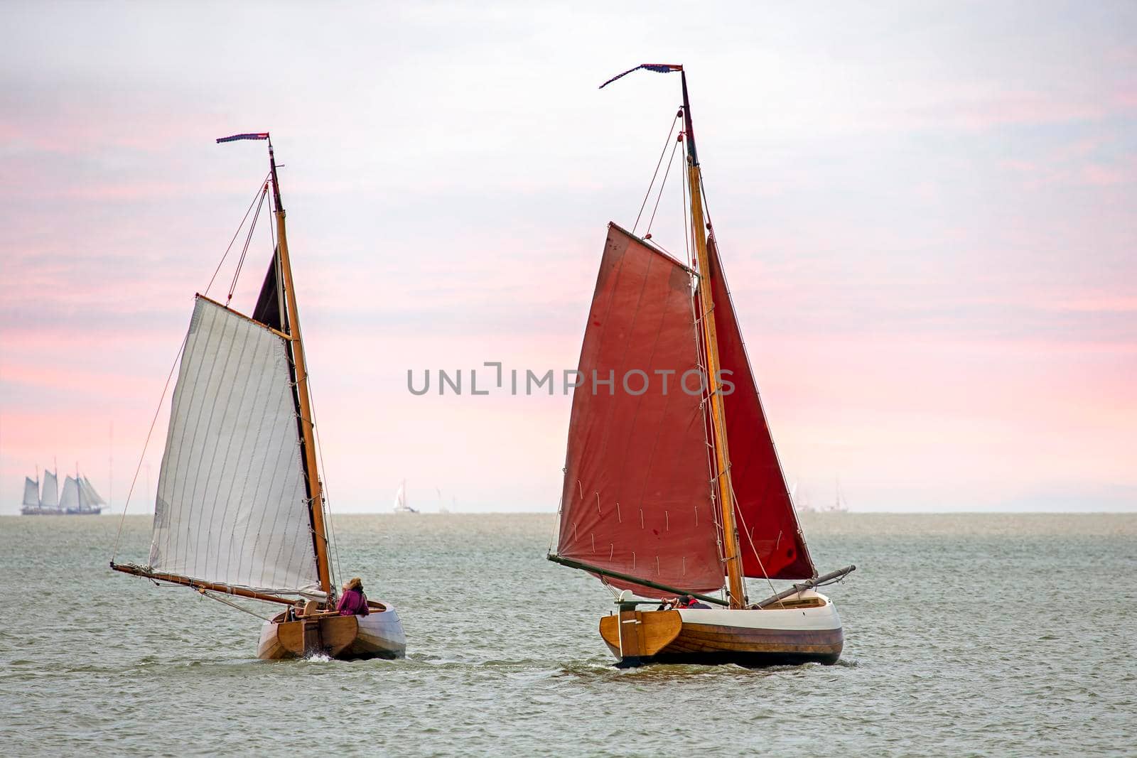 Traditional dutch wooden boats at the IJsselmeer in Friesland the Netherlands at sunset by devy