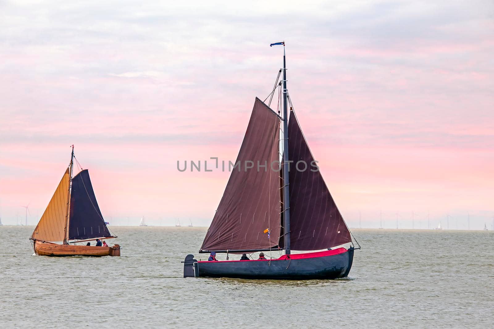 Traditional dutch wooden boats at the IJsselmeer in Friesland the Netherlands at sunset by devy