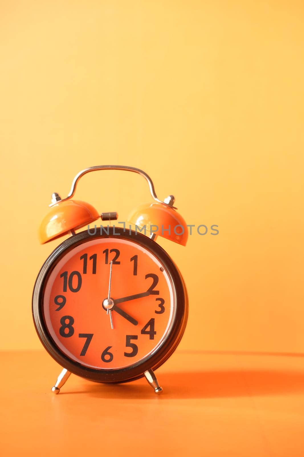 old alarm clock on orange background
