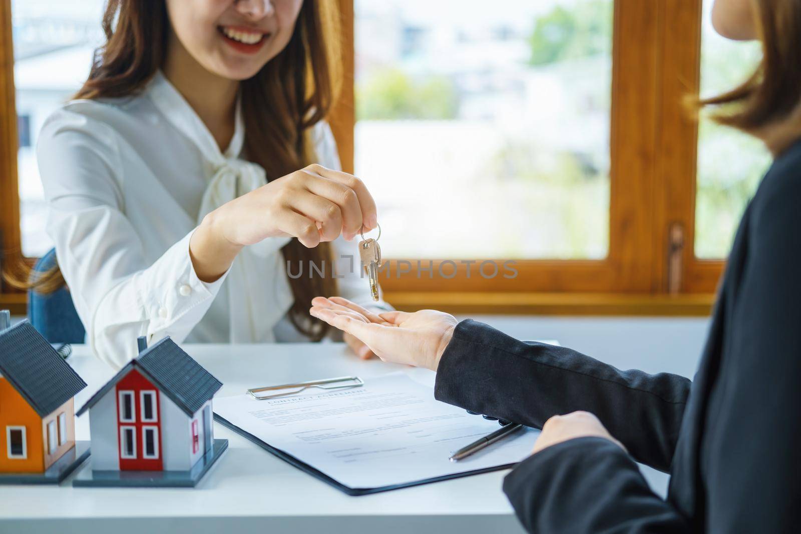 Guarantee, mortgage, agreement, contract, sign, real estate agent delivers the key to the customer after signing important contract documents by Manastrong