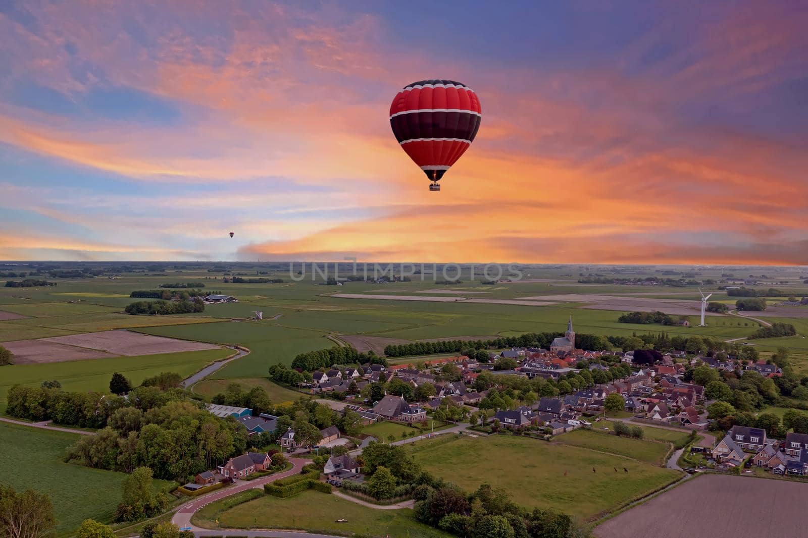 Aerial from a flying hot air balloon in the countryside from the Netherlands at sunset by devy