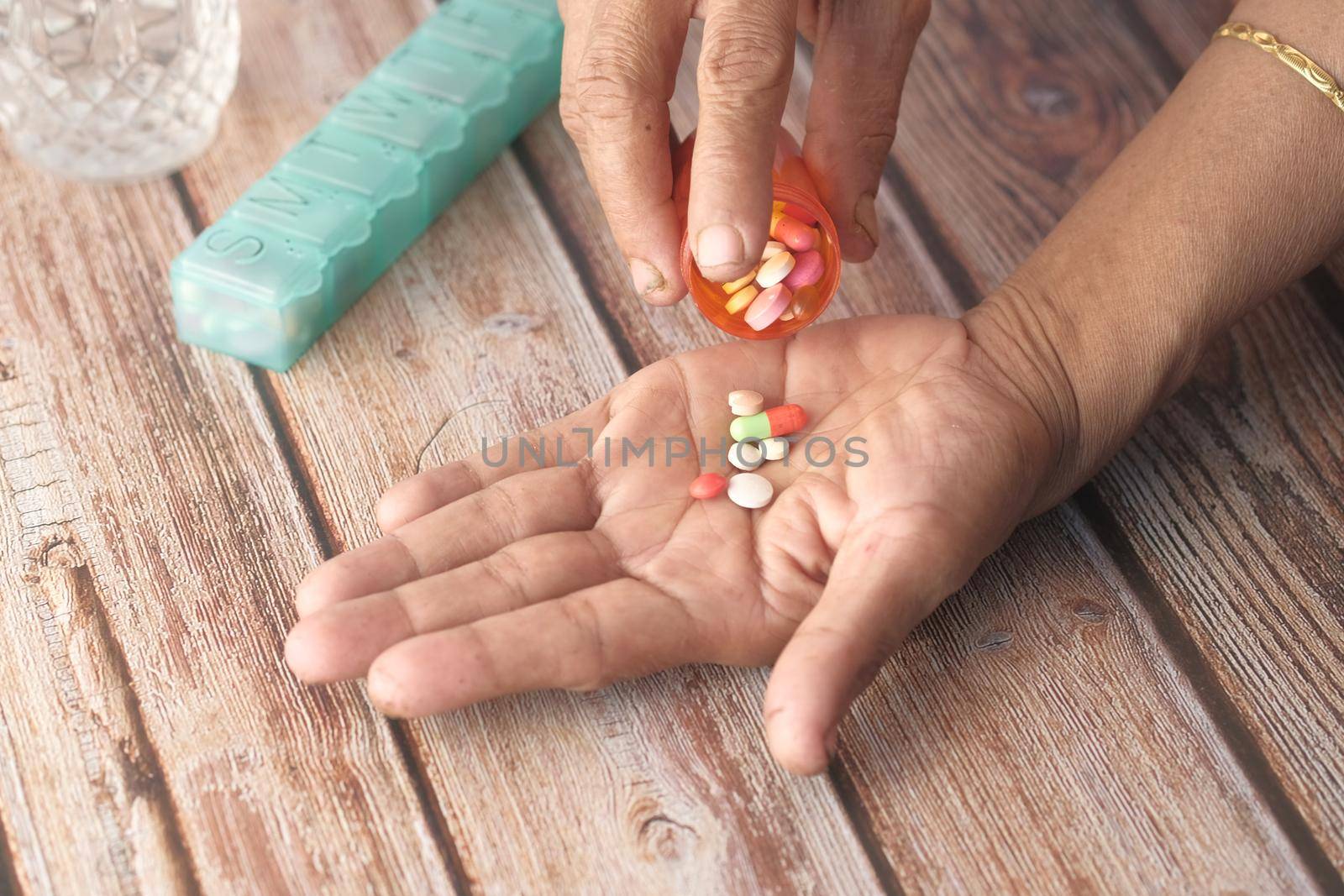 senior women hand's taking medicine, close up .