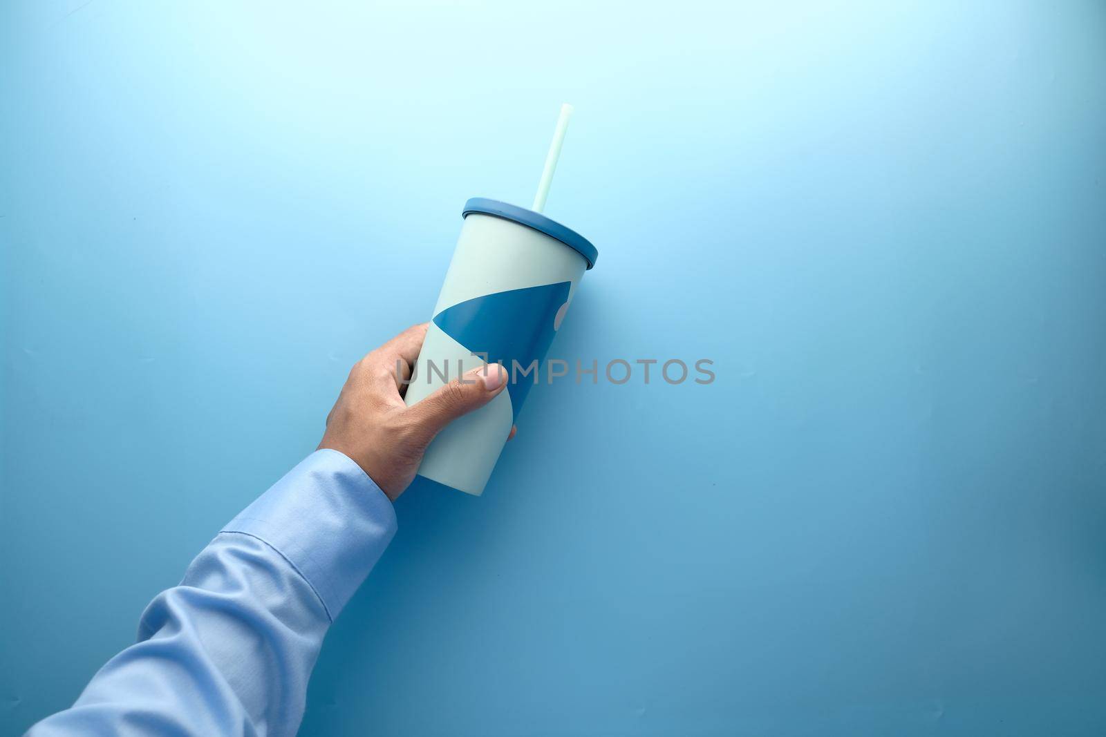 hand holding reusable eco coffee cup close up .