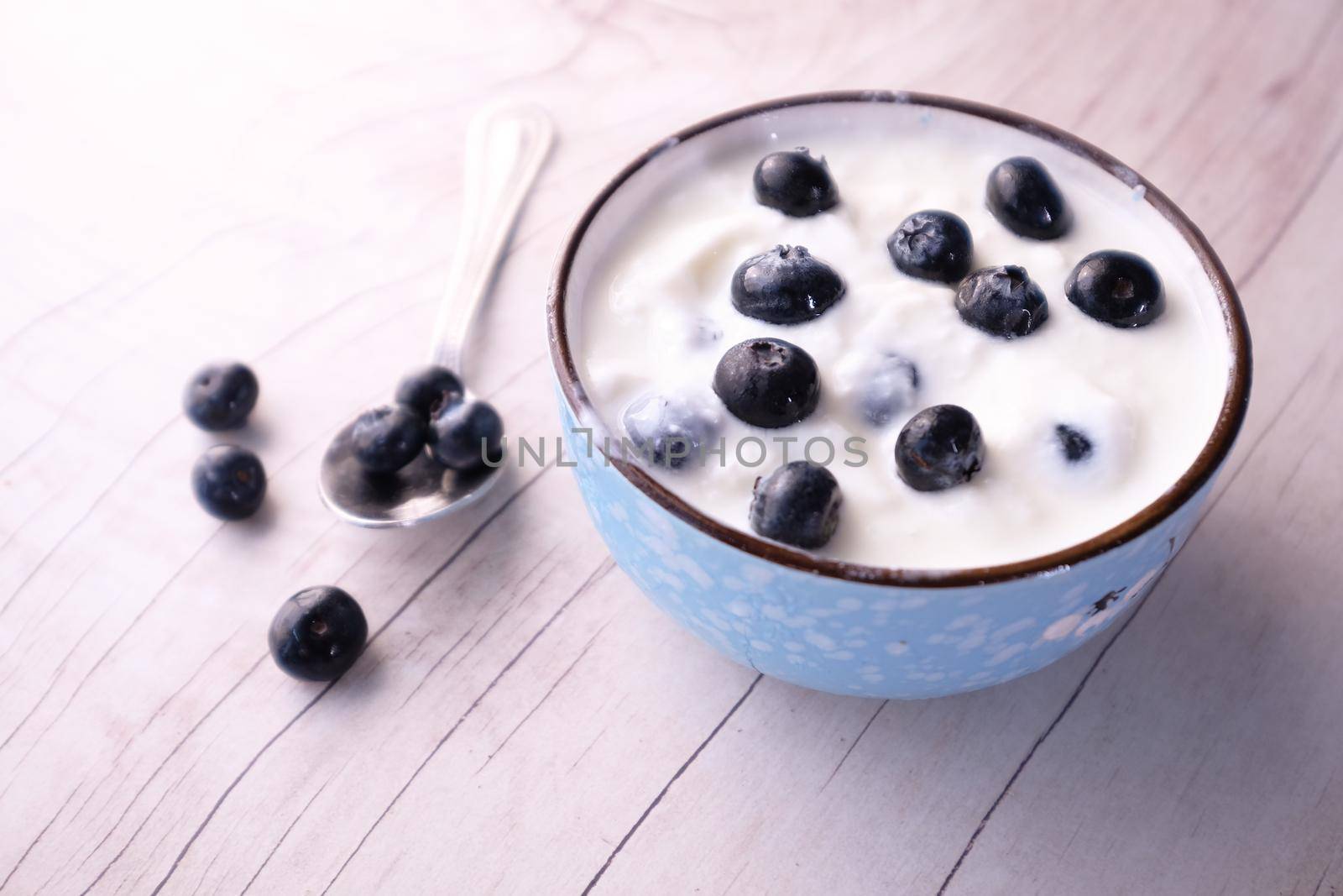 close up of fresh yogurt with blue berry in a bowl .