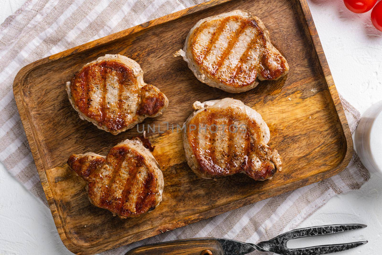 Baked pork fillet loin, on white stone table background, top view flat lay