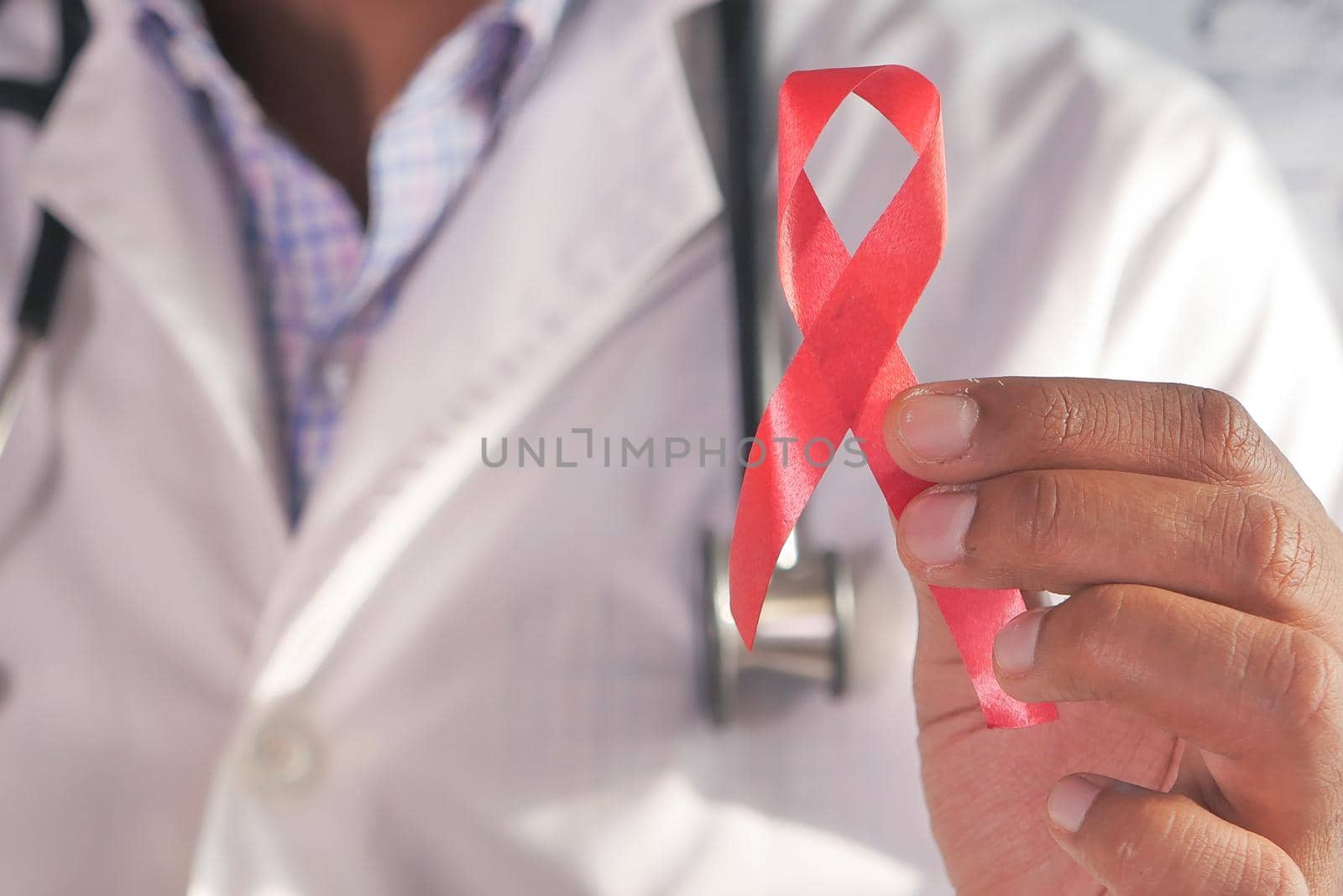 hand holding red HIV ribbon with copy space .