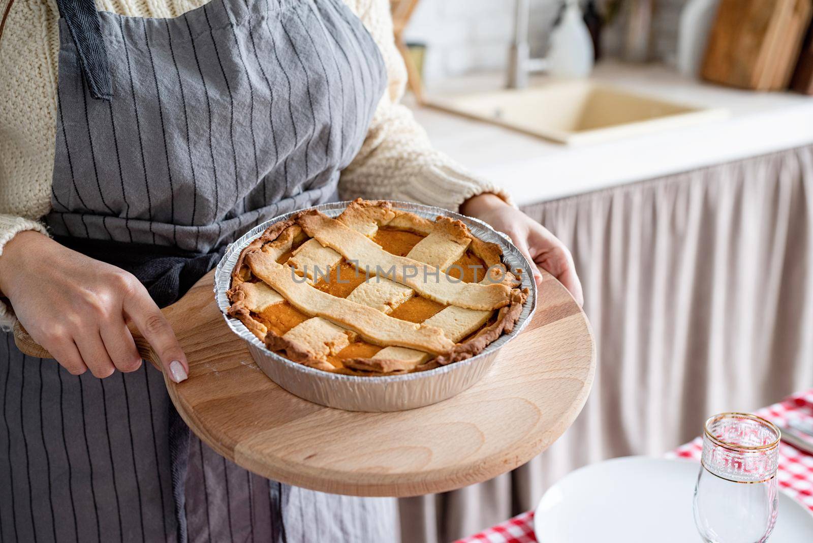 closeup of a woman hands holding pumpkin pie at home kitchen by Desperada