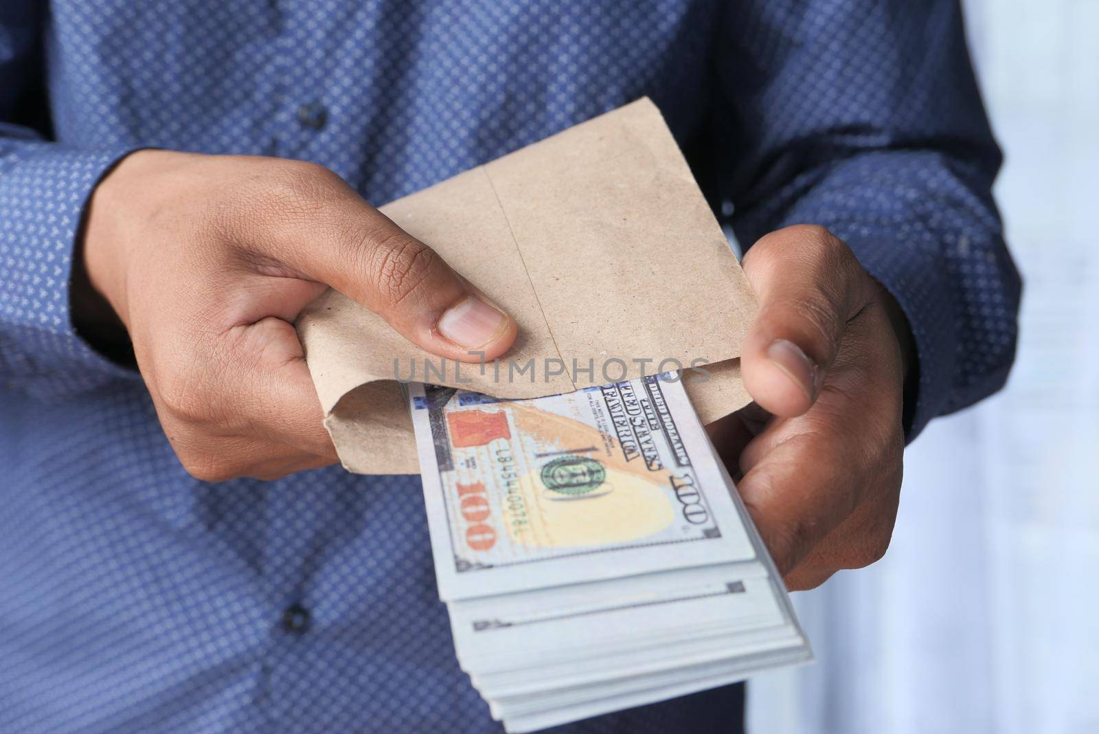 person hand putting cash in a envelope