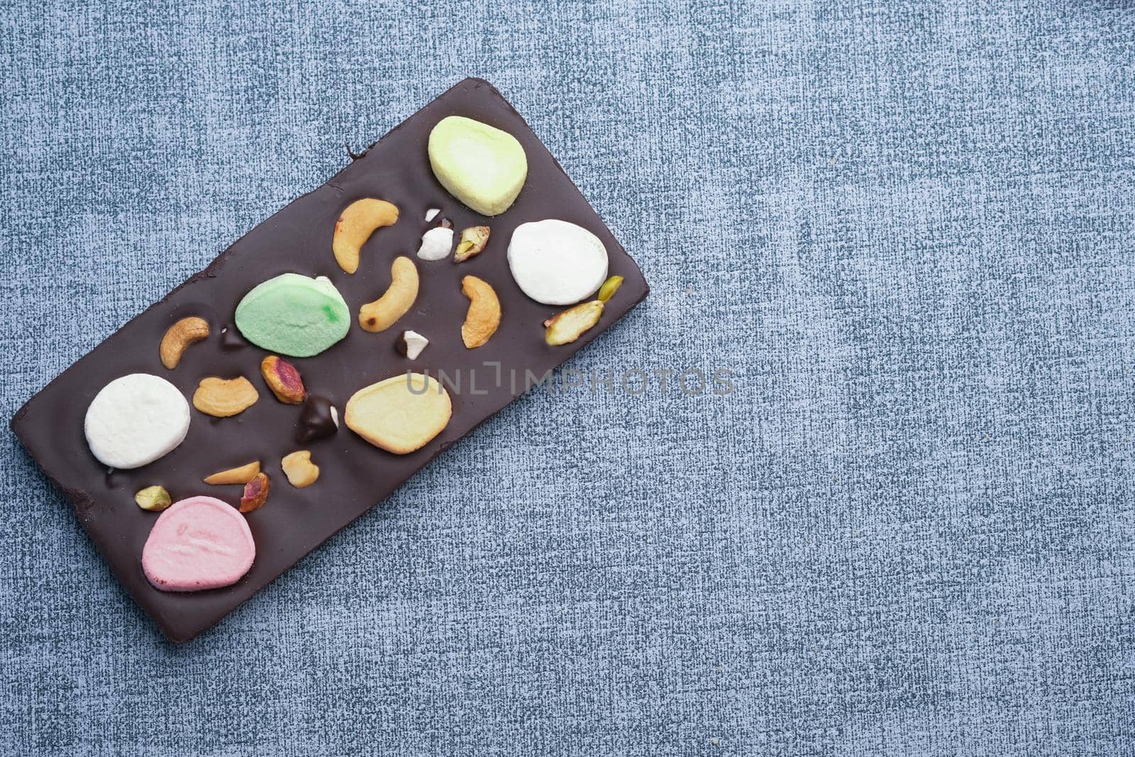 Nut candy in dark chocolate on table .