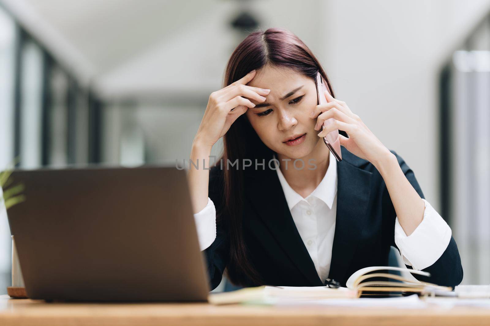 Portrait of Asian business woman worry about marketing plan of this years while talking with customer