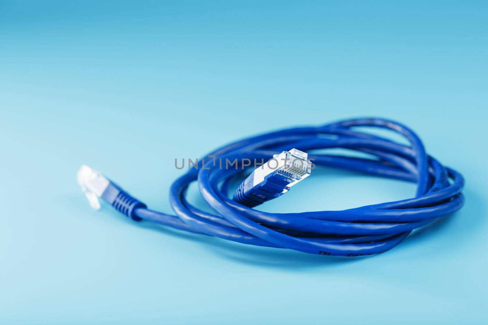 Blue Ethernet Cable Cord Patch cord on a blue background with free space by AlexGrec