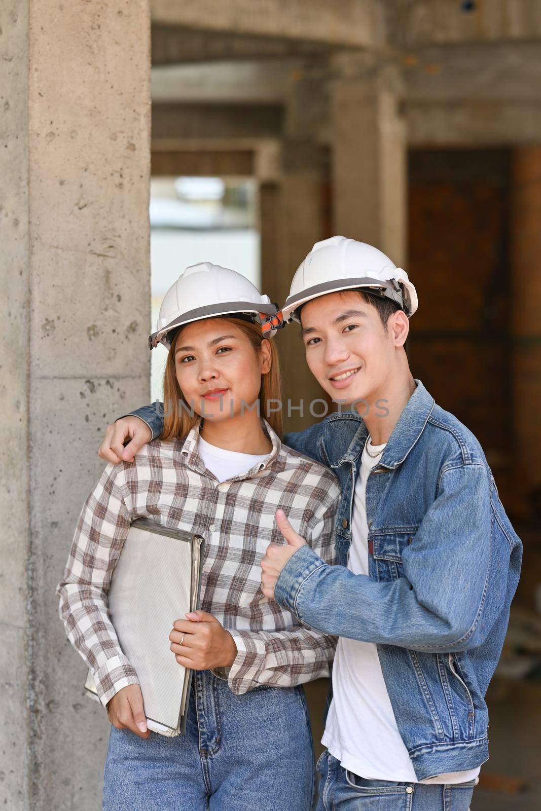 Two happy investors in helmet standing at construction site. Real estate investors concept.