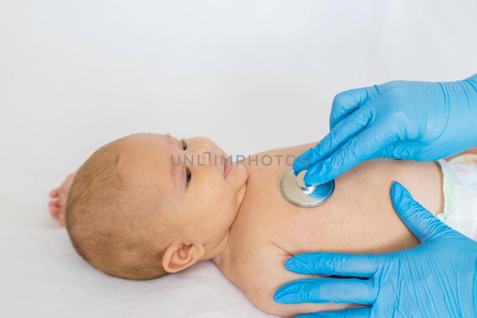 The doctor listens to the baby with a stethoscope. Selective focus. People.