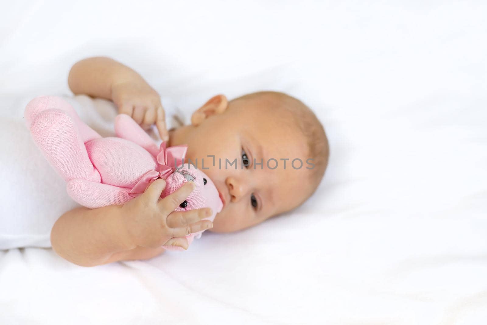 Baby plays with teddy bear against white background. Selective focus. People.