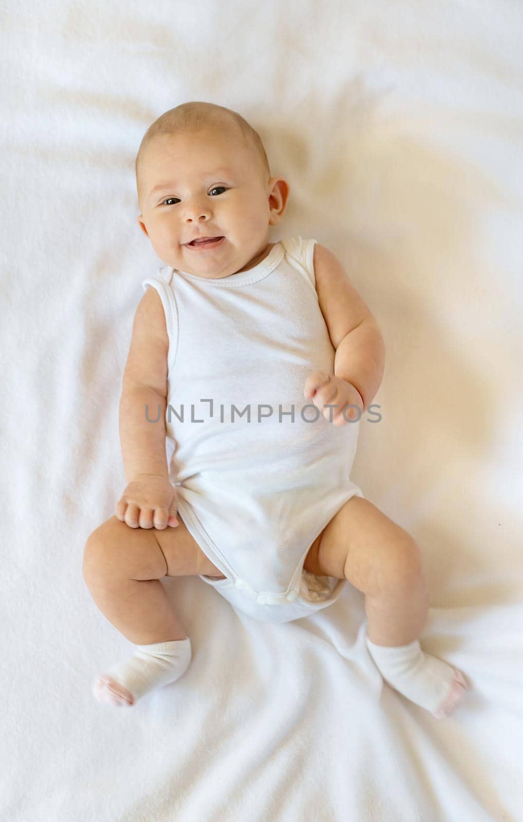 Baby smiles on a white background. Selective focus. People.