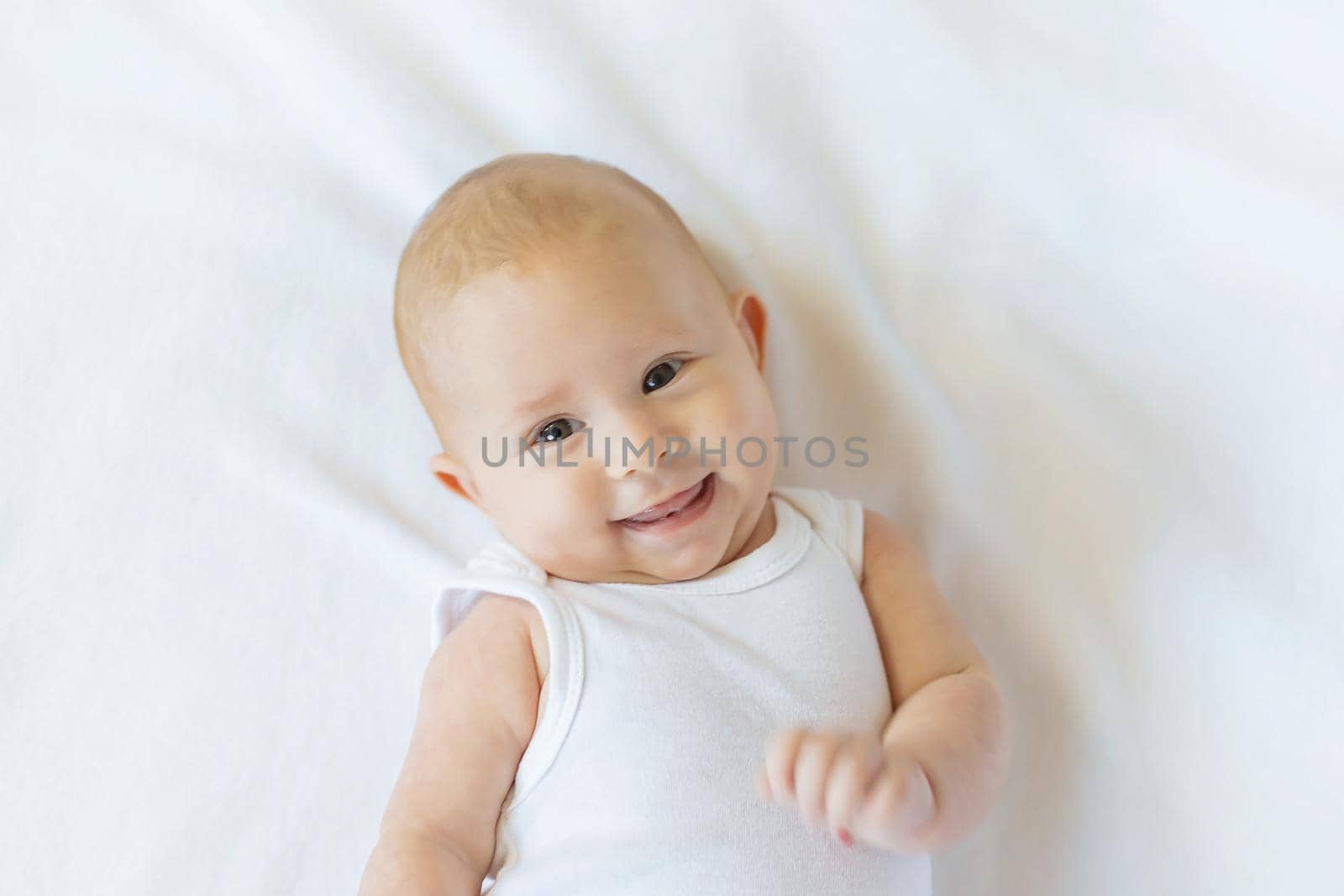 Baby smiles on a white background. Selective focus. People.