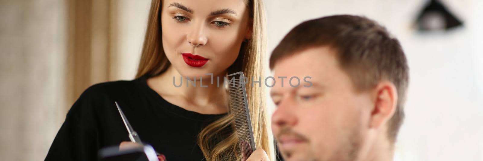 Portrait of barber girl and client discuss new hairstyle for him master gives advice. Talented woman worker in fashionable beauty salon. Barbershop concept