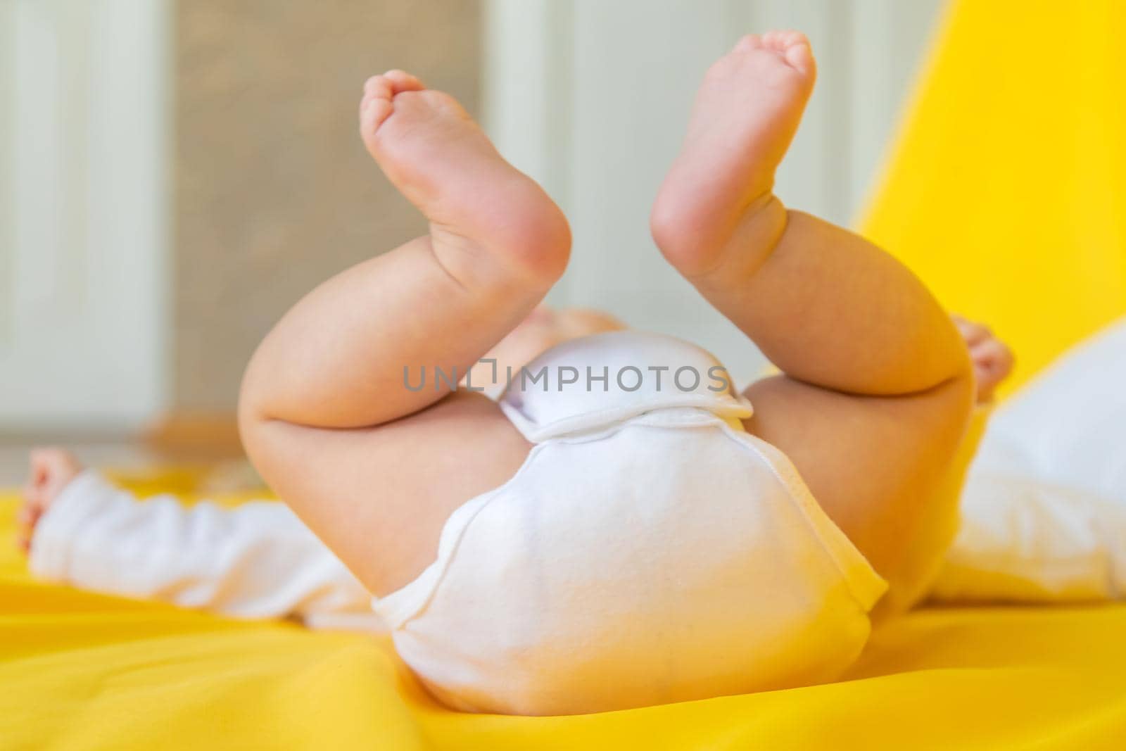 Baby feet on a yellow background. Selective focus. People. Merry Christmas and Happy New Year, Holidays greeting card background. Selective focus.