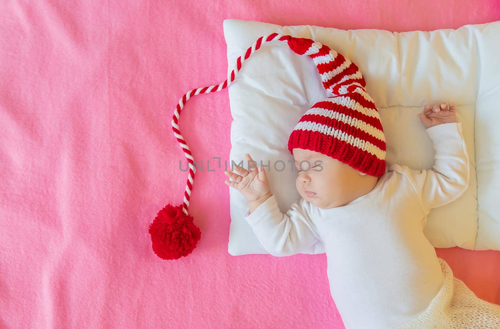 Baby sleeps in a Santa hat. Selective focus. People. Merry Christmas and Happy New Year, Holidays greeting card background. Selective focus.