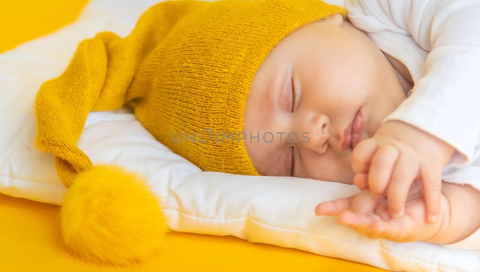 Baby sleeps on a yellow background. Selective focus. People. Merry Christmas and Happy New Year, Holidays greeting card background. Selective focus.